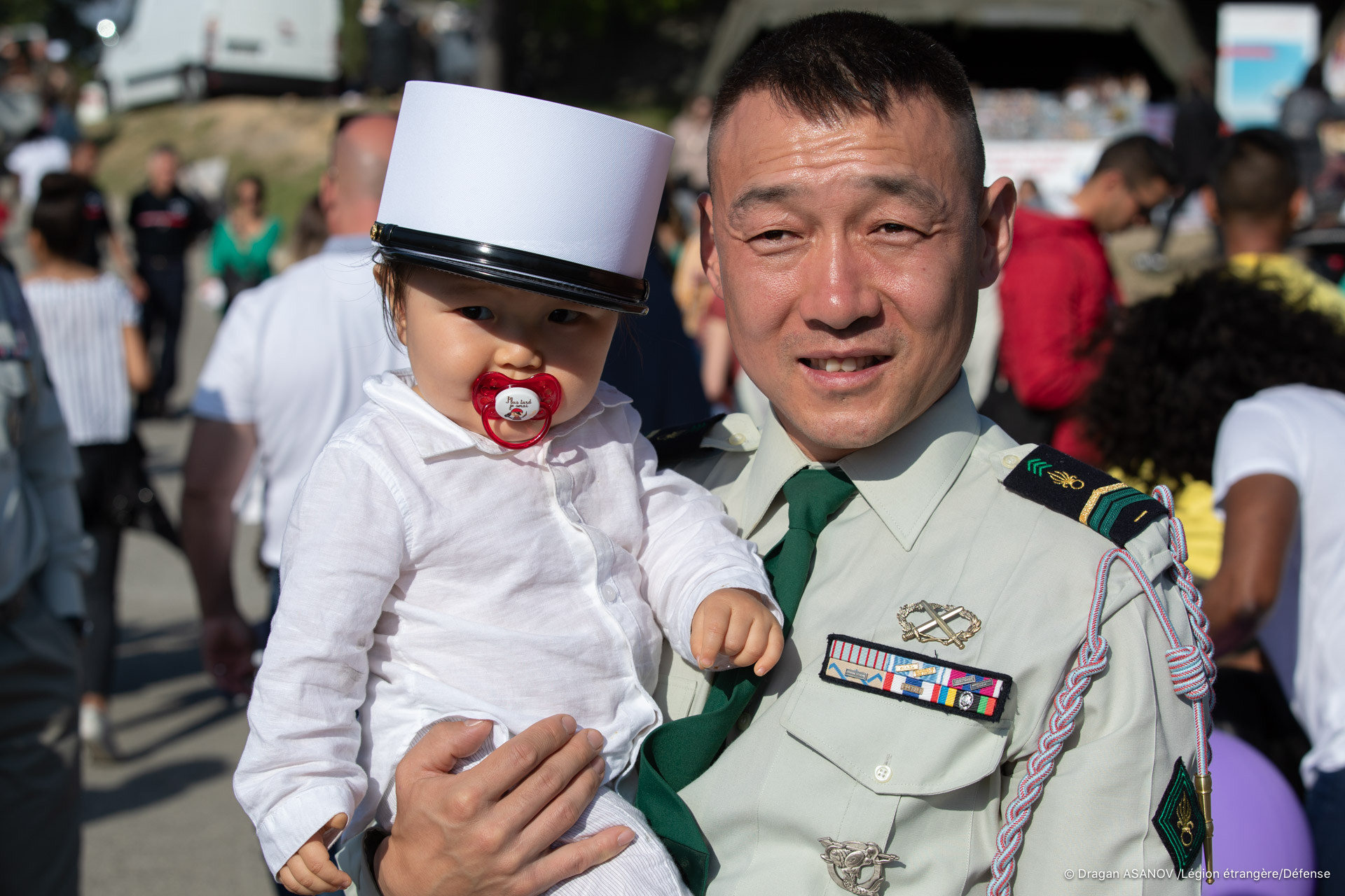 Un soldat tient son jeune enfant dans les bras 
